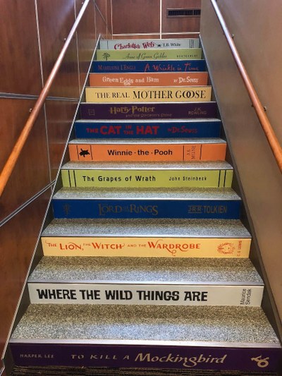 Photo of the 1st flight of stairs with book spine titles on risers